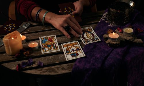 pythoness-reads-tarot-cards-table-with-candles pythoness-reads-tarot-cards-table-with-candles